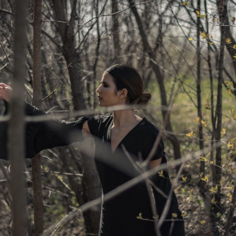 Model wearing black dress in the woods